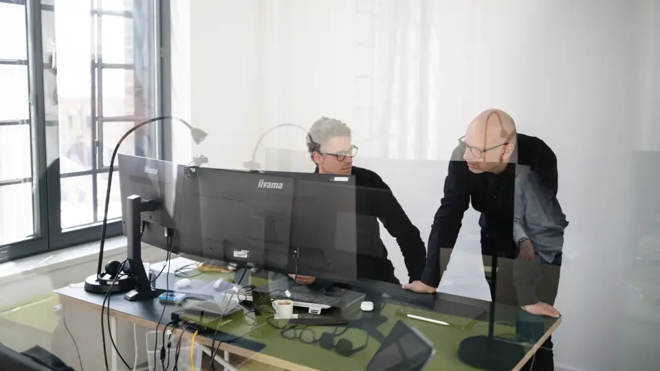 Zwei Kollegen besprechen am Bildschirm einen Entwurf im Büro von nattmann + bruns Architekten