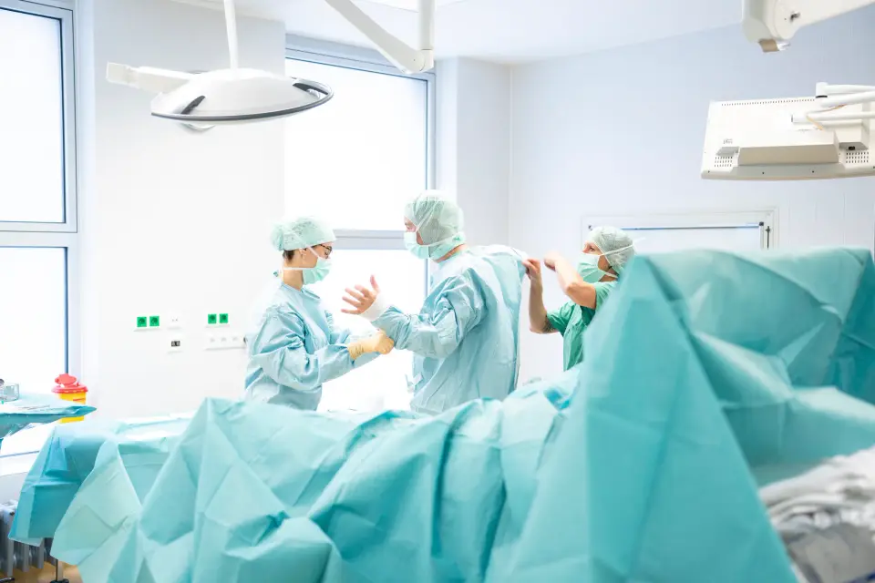 OP-Team in steriler Kleidung bereitet im hellen Operationssaal der Pan Klinik in Köln einen Eingriff vor