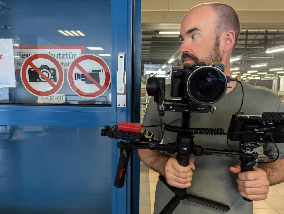 Fotograf Steve Brookland mit Kamera am Gimbal bei einem Videodreh in einer Produktionshalle